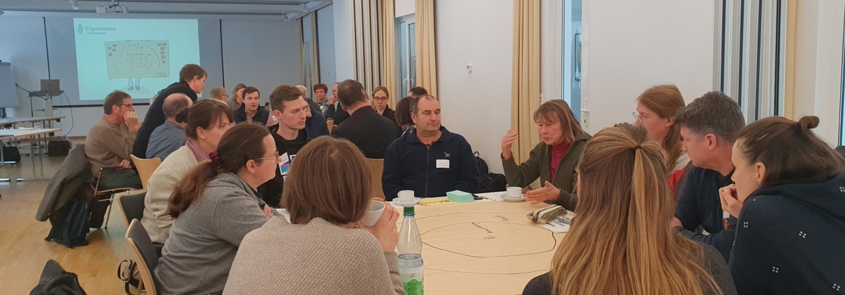 Rege Diskussion an zwei Gruppenarbeitstischen