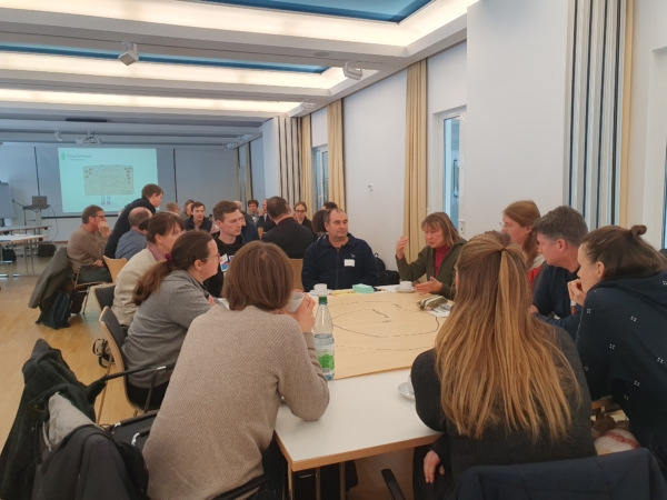 Rege Diskussion an zwei Gruppenarbeitstischen